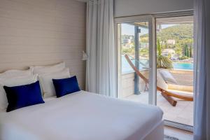 a bed with blue pillows in a room with a balcony at Tara's Lodge Hotel in Korčula