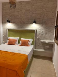 een slaapkamer met een bed met 2 oranje kussens bij Ammos 1 in Panteli