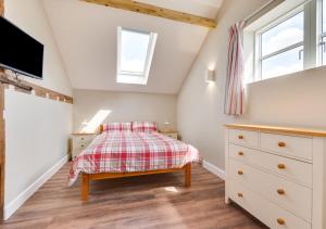 a bedroom with a bed and a tv in a attic at The Cartlodge in Woolpit