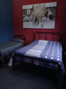 a bedroom with two beds in a red wall at Blue Pine Farm Lodge Cabanas in Coroico