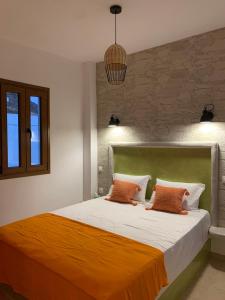 a bedroom with a bed with two orange pillows at Ammos 1 in Panteli