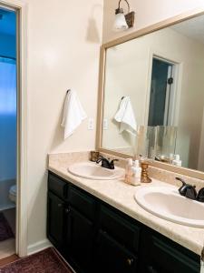 La salle de bains est pourvue de 2 lavabos et d'un grand miroir. dans l'établissement The Mini Mansion at Graceland, à Memphis