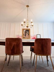 a dining room table with two chairs and a chandelier at The Mini Mansion at Graceland in Memphis