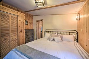 1 dormitorio con 1 cama con sábanas blancas y paredes de madera en Glamping Getaway in Woodstock Lake Campground, en East Berne