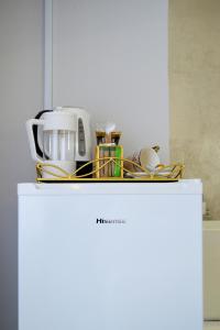 a white refrigerator with a pile of dishes on it at Augusta Palms - White Room in Centurion
