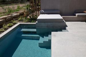 a swimming pool with blue water in a yard at Pure Villas in Ormos Panagias