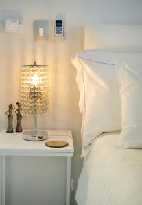 a bed with a lamp on a table next to a bed at Augusta Palms - White Room in Centurion