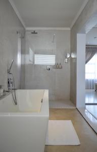 a white bathroom with a tub and a shower at Augusta Palms - White Room in Centurion