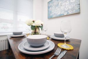 un tavolo con una ciotola, dei piatti e un vaso di fiori di 2 Bedroom House on Holmes Hill Road- Free Parking, Wi-Fi & Patio a Bristol Altre 28 foto