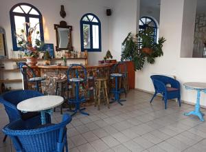 a bar with blue chairs and tables in a restaurant at Daidalos Hotel in Armenistis