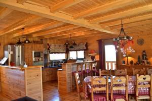 eine Küche und ein Esszimmer mit einem Tisch in einer Hütte in der Unterkunft Chalet le Lagopède in La Joue du Loup