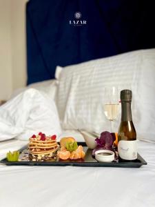 a tray of food and a glass of wine on a bed at Lazar Winery Tourism B&B in Rosoman