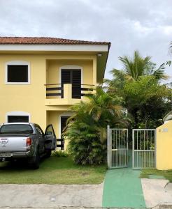 a car parked in front of a house with a gate at Apartamentos Araraquara in Ilha Comprida