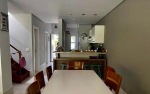 - une cuisine et une salle à manger avec une table et des chaises dans l'établissement Casa Pé na Areia, à Praia do Paúba
