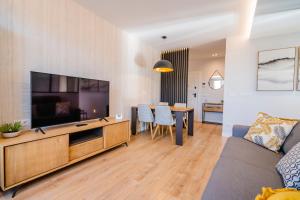 Cid Campeador I - Apartamentos Burgos Deluxe في برغش: غرفة معيشة مع أريكة وغرفة طعام