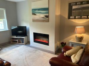 a living room with a fireplace and a tv at Home from Home in Tralee