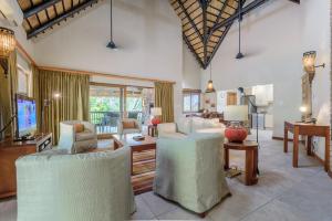 a living room with white chairs and a tv at Kruger Park Lodge Unit No. 547 in Hazyview