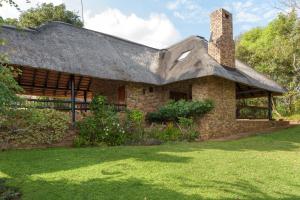 an old brick house with a thatched roof at Kruger Park Lodge Unit No. 547 in Hazyview
