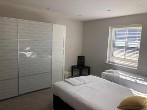 a bedroom with two beds and a closet and a window at Captivating 2-Bed Apartment in Brentwood in Brentwood