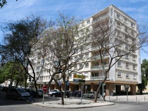 een hoog wit gebouw met bomen ervoor bij Casa Encantada - Elias in Lissabon