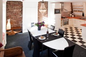 アムステルダムにあるCanal Holiday Apartmentの白いテーブルと椅子のあるキッチンとダイニングルーム