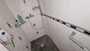 a bathroom with a shower and a black and white floor at Appartement familial avec balcon in Trosly-Breuil