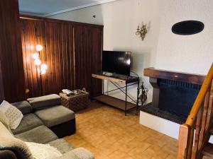 uma sala de estar com um sofá e uma lareira em Casa en Cambeo em Ourense