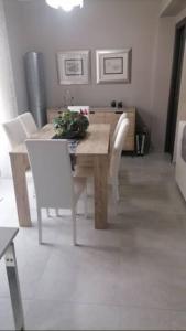 a dining room with a table and white chairs at SoleLuna Apartment 2 in Santa Elisabetta