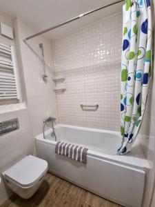 uma casa de banho branca com uma banheira e um WC em Riverside Apartment em Podgorica