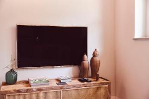 a flat screen tv sitting on top of a table at AQVAE Unconventional Country House in Oglianico