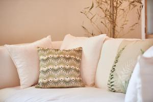 a group of pillows on a white couch at AQVAE Unconventional Country House in Oglianico