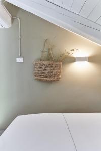 a plant in a basket hanging on a wall at AQVAE Unconventional Country House in Oglianico