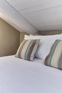 two white pillows on a bed in a room at AQVAE Unconventional Country House in Oglianico