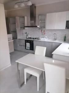 a kitchen with a white table and white chairs at SoleLuna Apartment 2 in Santa Elisabetta