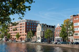 un grupo de edificios junto a un río en Canal Holiday Apartment, en Ámsterdam