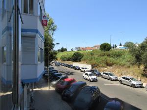 un parcheggio con auto parcheggiate accanto a un edificio di Casa Encantada - Benfica a Lisbona