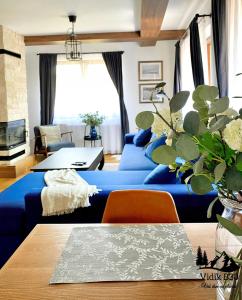 a living room with blue couches and a table at Vidik B30 in Kopaonik