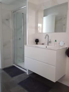 ein weißes Bad mit einem Waschbecken und einer Dusche in der Unterkunft Bel appartement 3 chambres vue port de Golf Juan in Vallauris