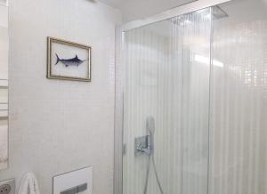 ein Bad mit einer Dusche und ein Bild von einem Fisch an der Wand in der Unterkunft Bel appartement 3 chambres vue port de Golf Juan in Vallauris