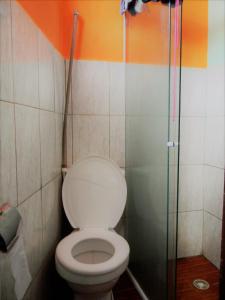 La salle de bains est pourvue de toilettes et d'une douche en verre. dans l'établissement Jahostel, à Lençóis