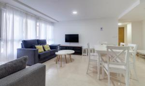 ein Wohnzimmer mit einem blauen Sofa und einem Tisch in der Unterkunft Duerming Family Viveiro 4 Rooms in Viveiro