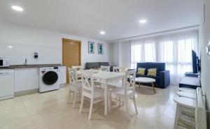 eine Küche und ein Wohnzimmer mit einem weißen Tisch und Stühlen in der Unterkunft Duerming Family Viveiro 4 Rooms in Viveiro