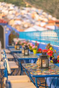 uma fila de mesas azuis com flores em VANCII Hotel em Chefchaouen