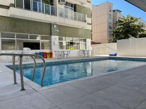 a swimming pool in front of a building at Precioso apartamento con terraza y piscina in Rio de Janeiro