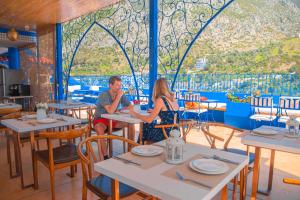 Ein Mann und eine Frau sitzen an einem Tisch in einem Restaurant in der Unterkunft VANCII Hotel in Chefchaouen