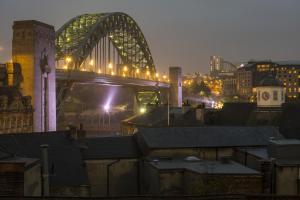 a view of a bridge over a city at night at easyHotel Newcastle in Newcastle upon Tyne