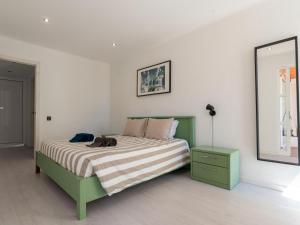 - une chambre avec un lit vert et un miroir dans l'établissement Cosy beach apartment in Albufeira centre, à Albufeira