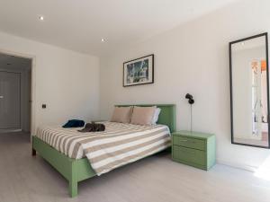 1 dormitorio con cama verde y espejo en Cosy beach apartment in Albufeira centre, en Albufeira