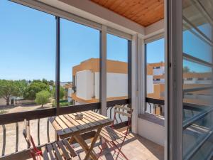 d'un balcon avec une table, des chaises et des fenêtres. dans l'établissement Cosy beach apartment in Albufeira centre, à Albufeira