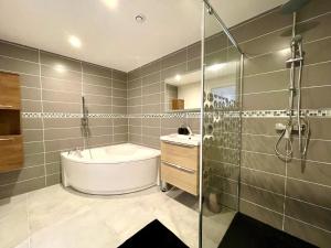 a bathroom with a tub and a sink and a shower at Residence Belfort in Le Mans